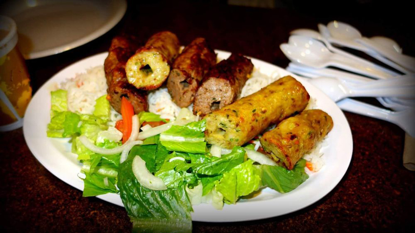 Skewers of grilled meat and peppers over an open flame